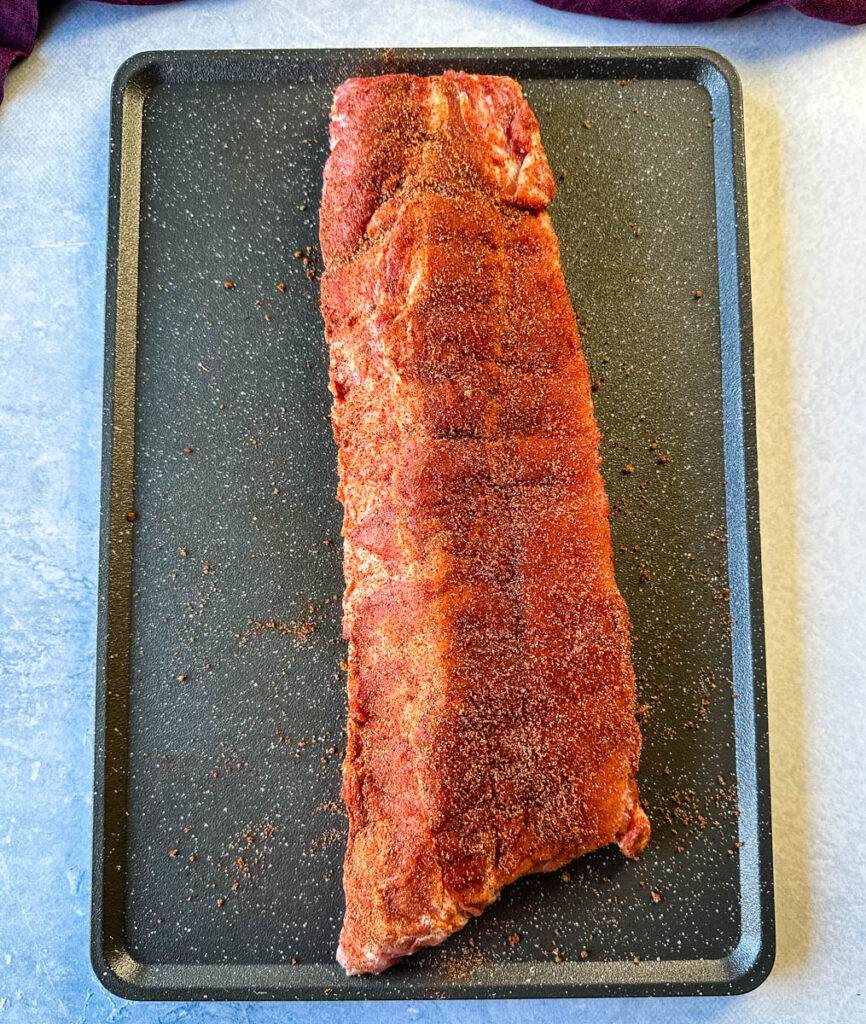 seasoned raw pork ribs on a sheet pan