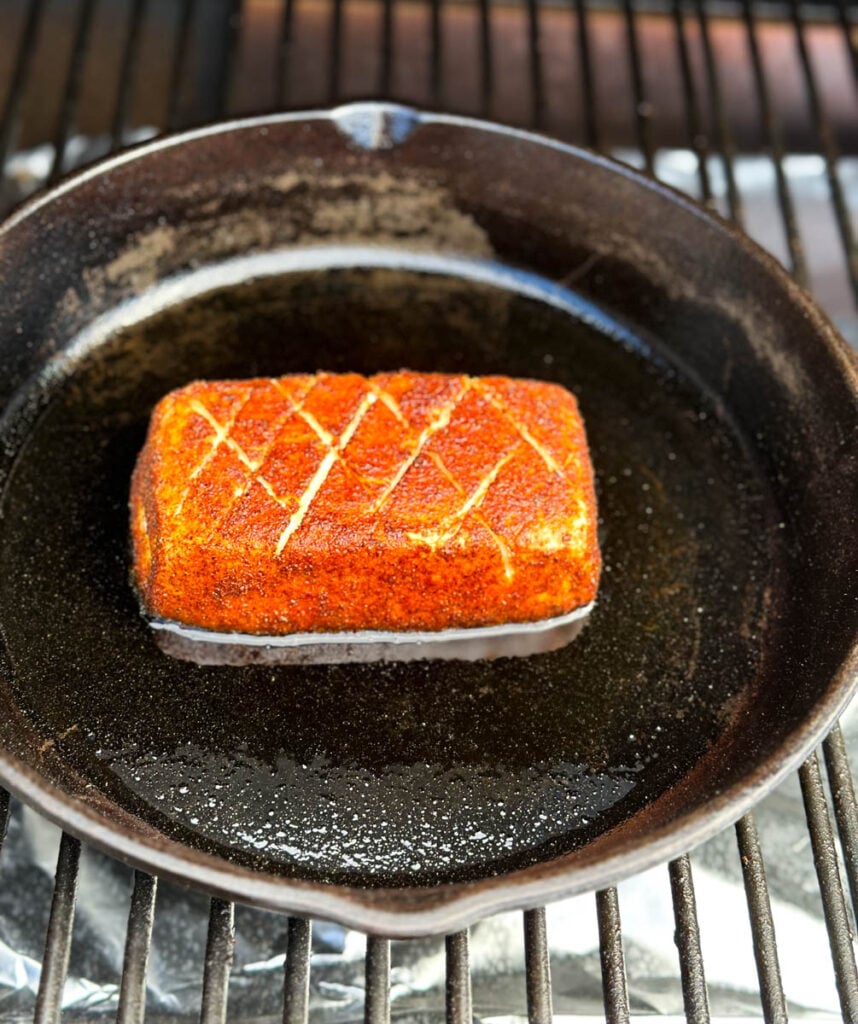 smoked cream cheese in a cast iron skillet on a Traeger pellet grill