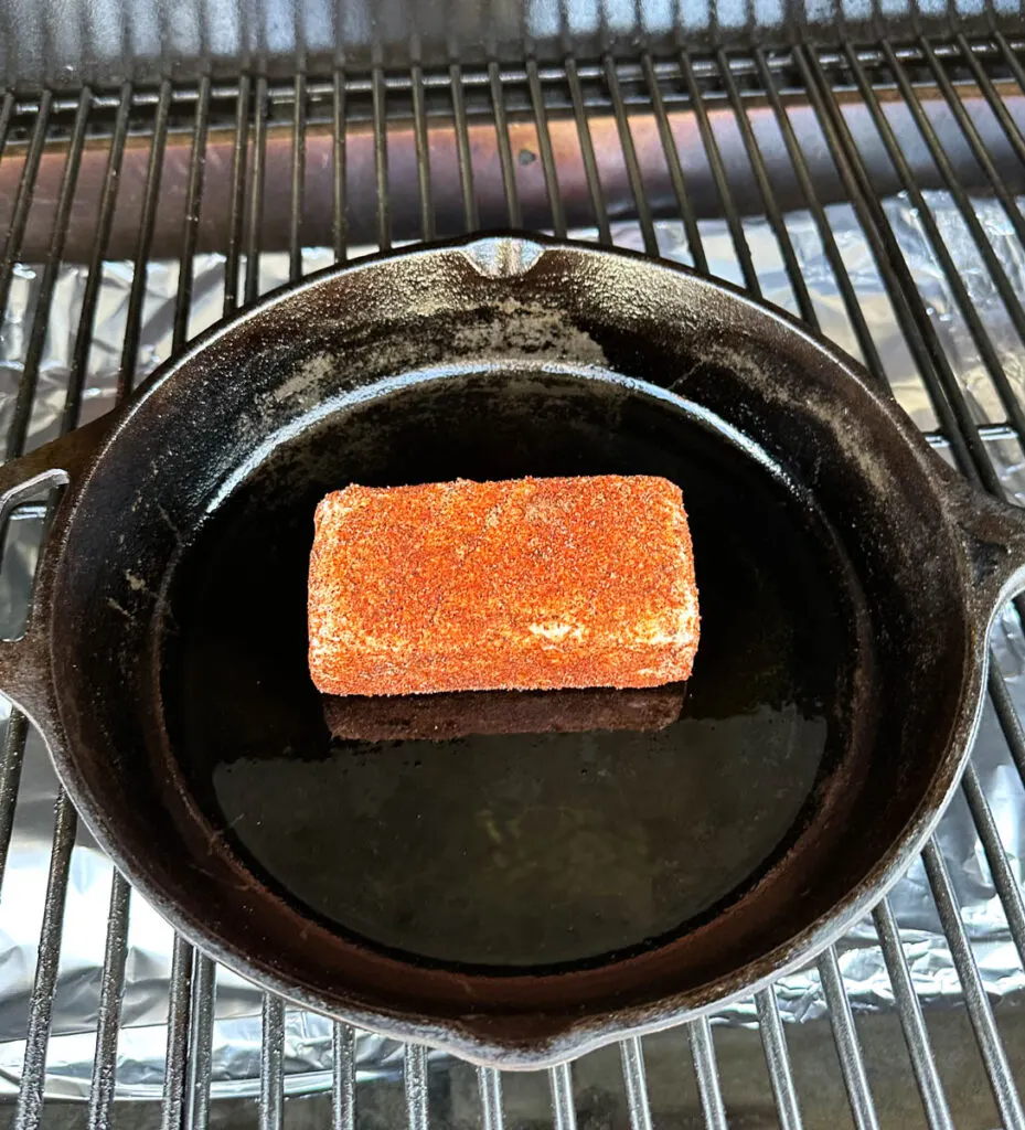 smoked cream cheese in a cast iron skillet on a Traeger pellet grill