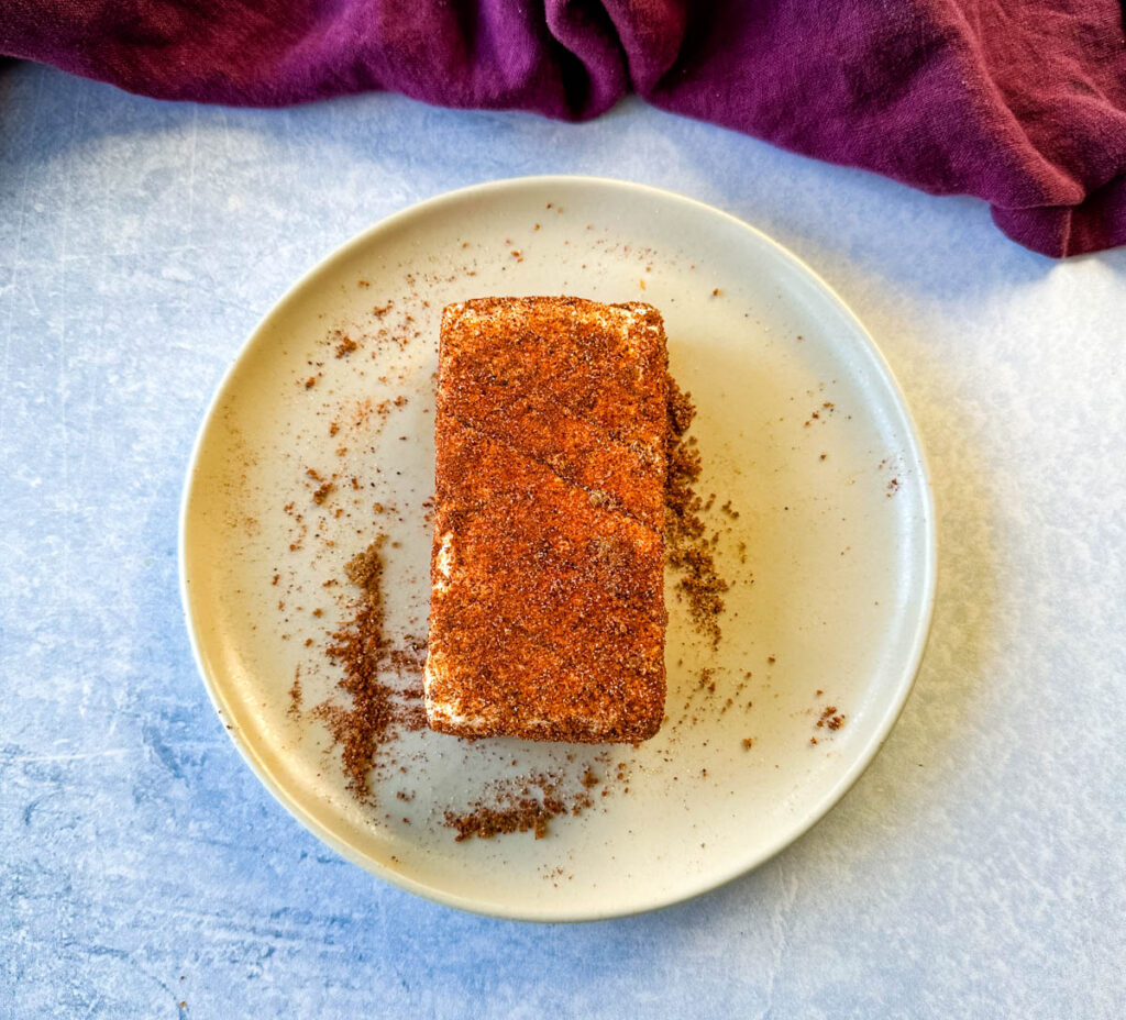 cream cheese rubbed in a homemade BBQ rub seasoning on a plate