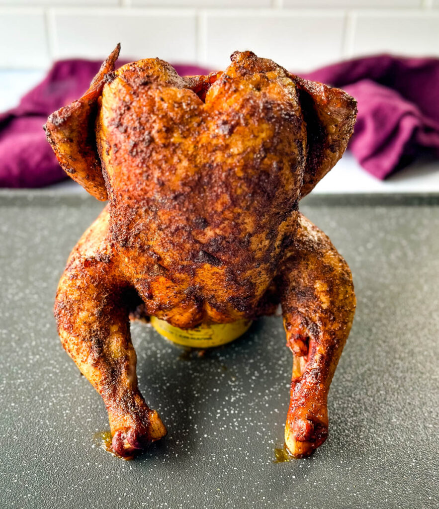 cooked, smoked seasoned whole chicken on a beer can