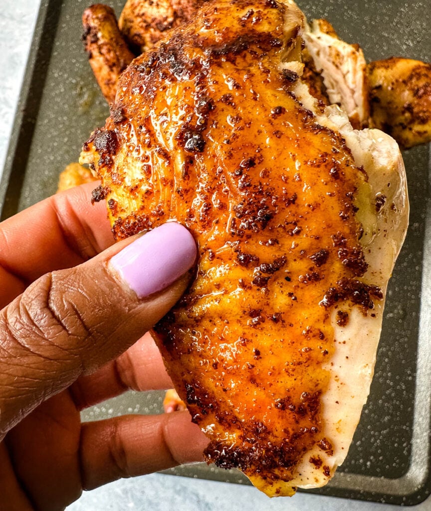 person holding a slice of Traeger beer can chicken