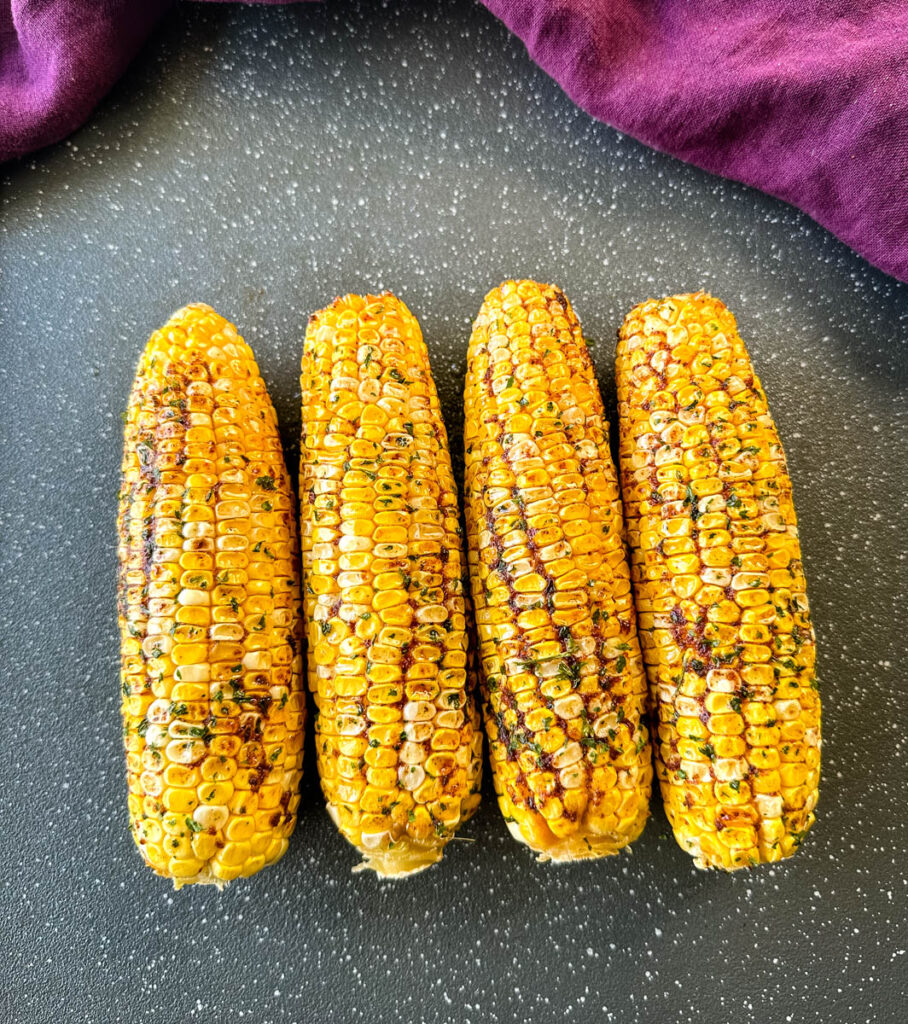 Traeger smoked corn on the cob with garlic butter on a sheet pan