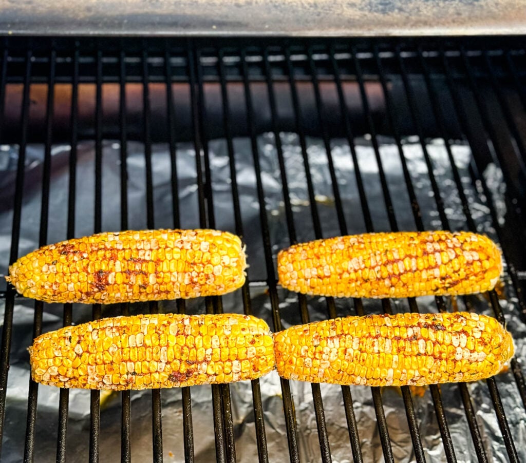 fresh corn on the cob ears with smoked garlic butter and spices on a Traeger smoker pellet grill