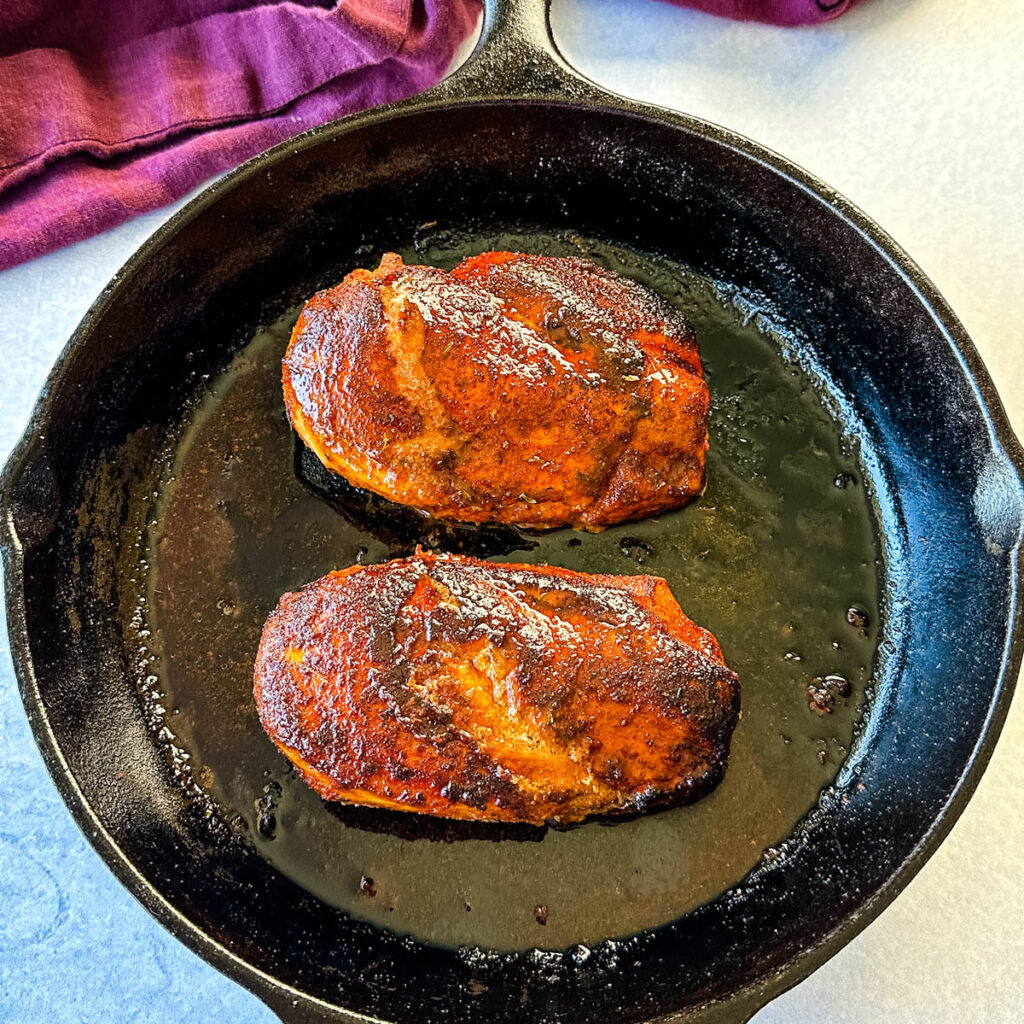 cooked blackened chicken breasts in a cast iron skillet