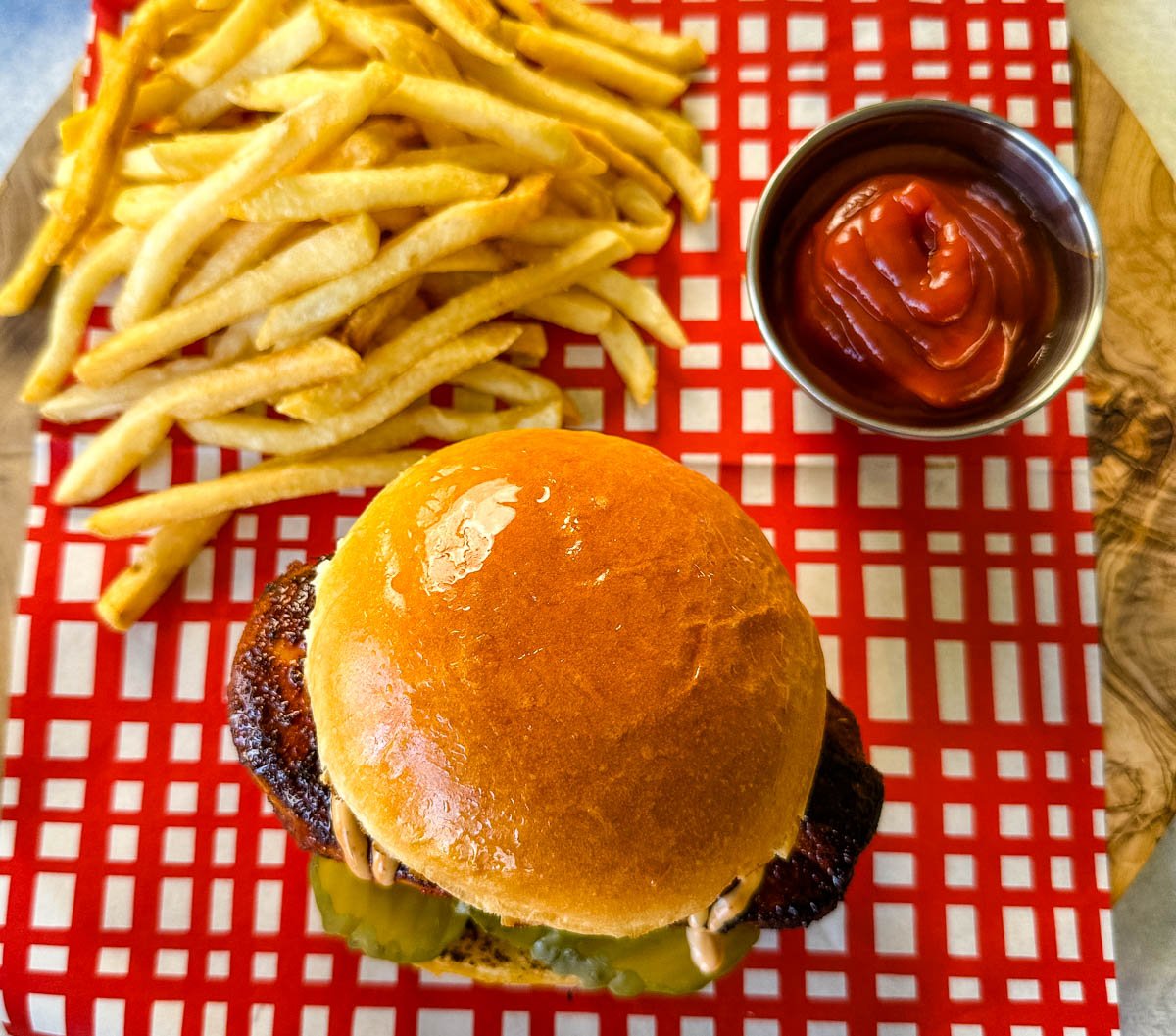 blackened chicken sandwich on a bun with spicy mayo on a plate with fries