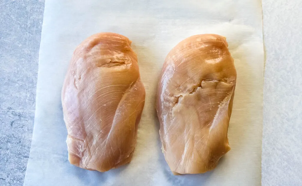 raw chicken breast on parchment paper