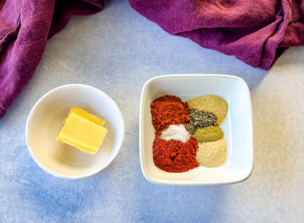 butter and homemade blackening seasoning spices in separate white bowls