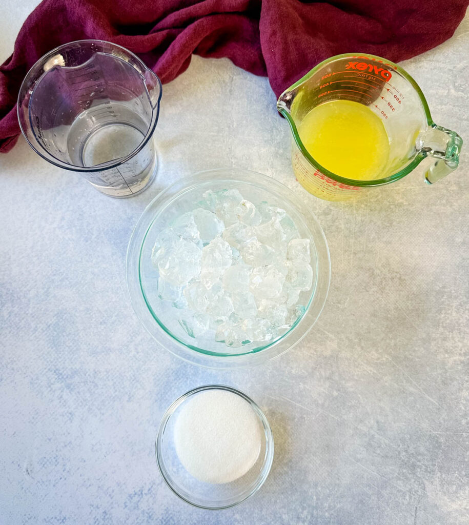 water, fresh lemon juice, ice, and sweetener in separate glass bowls