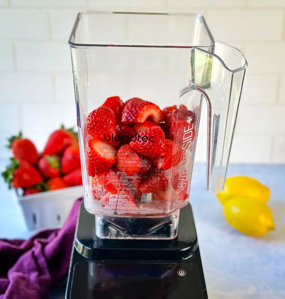 fresh cut strawberries in a blender
