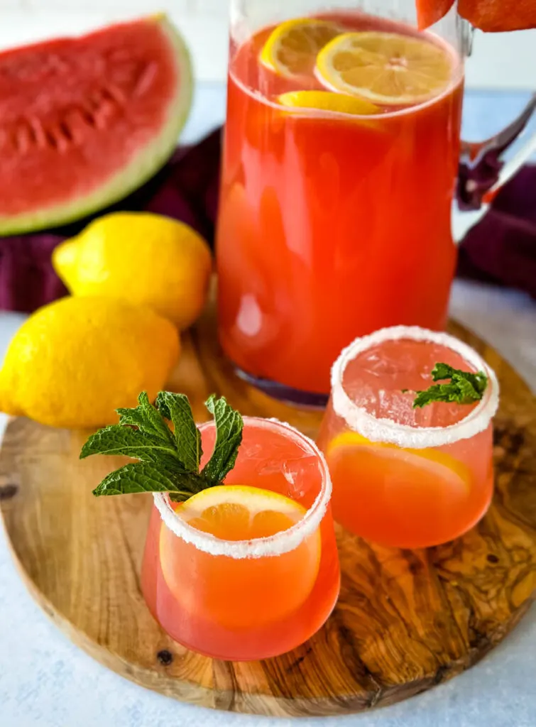 watermelon lemonade in glasses and a pitcher with fresh watermelon and lemons