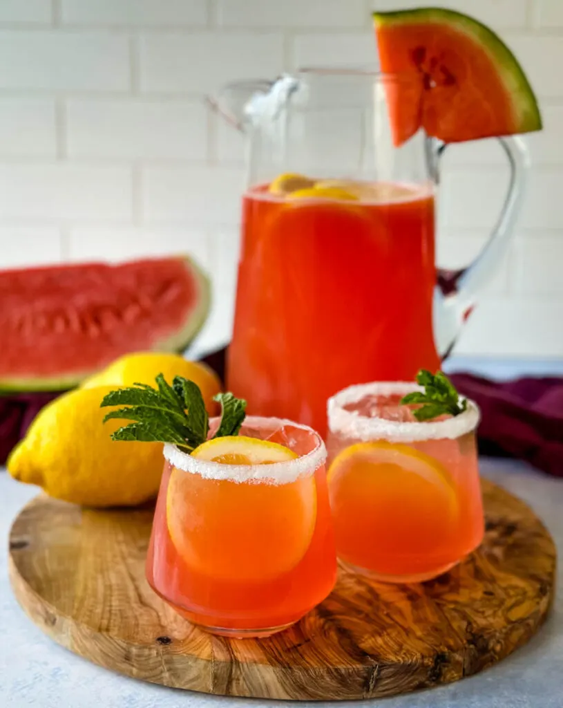 watermelon lemonade in glasses and a pitcher with fresh watermelon and lemons