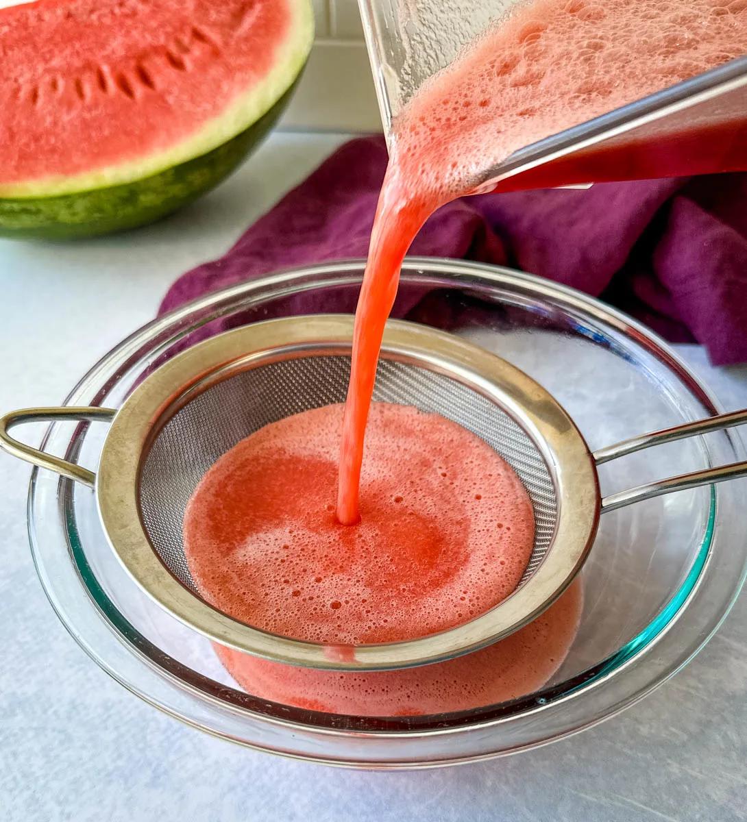 pureed watermelon poured into a strainer