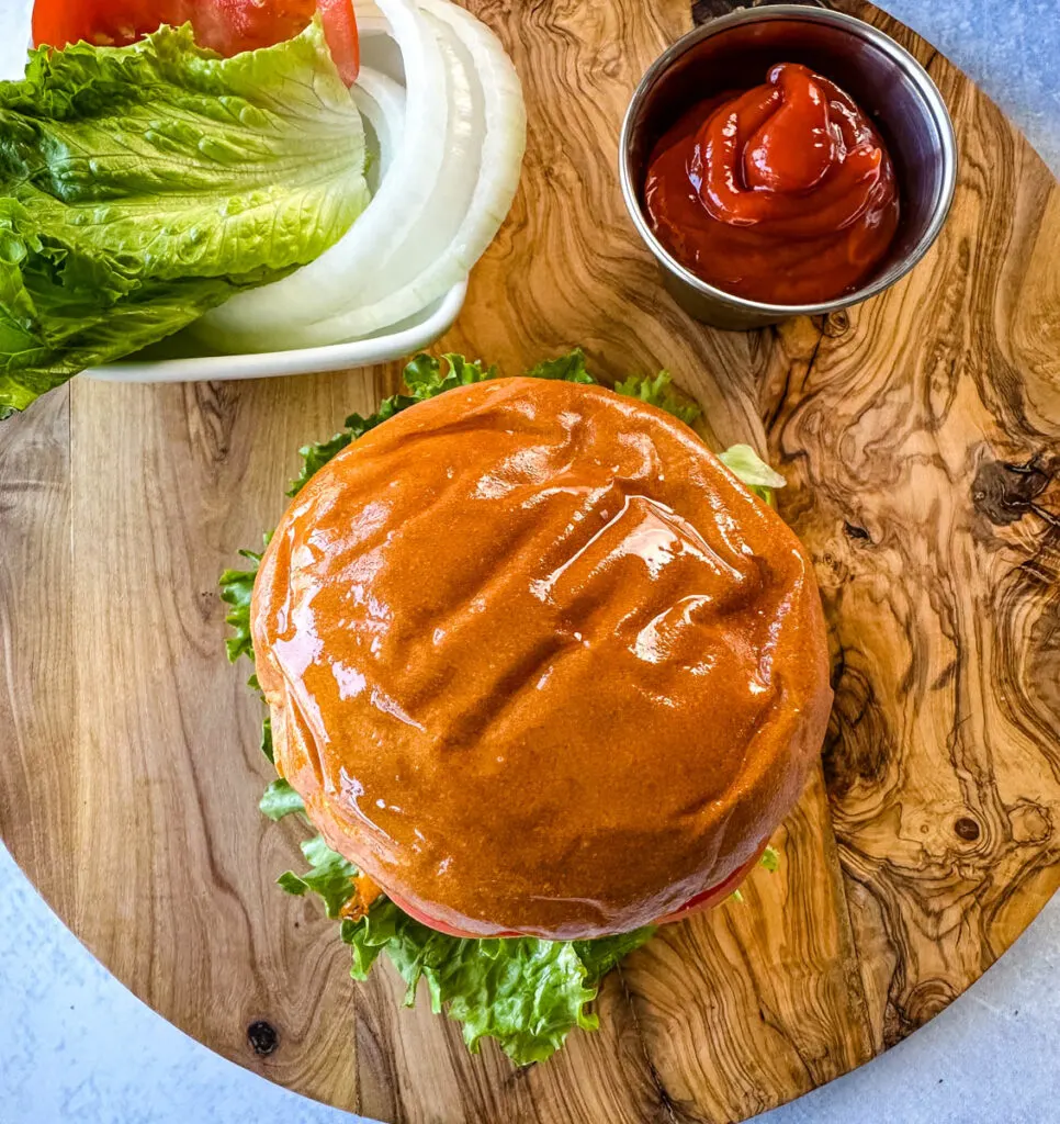 Traeger smoked burger on a bun with cheese, lettuce, tomato, and onions