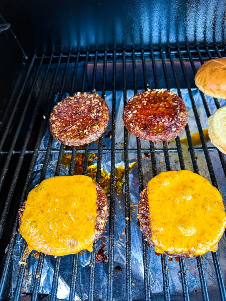 burgers on a Traeger smoker grill with cheese