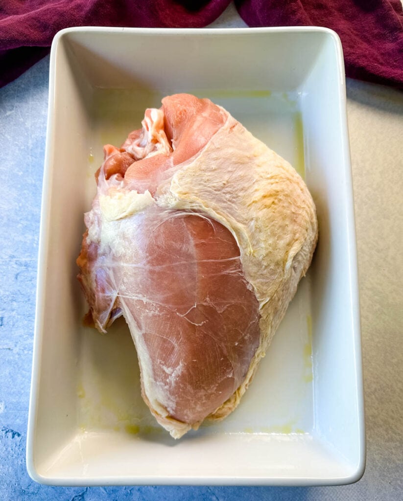 raw bone in turkey breast in a white 9x13 baking dish