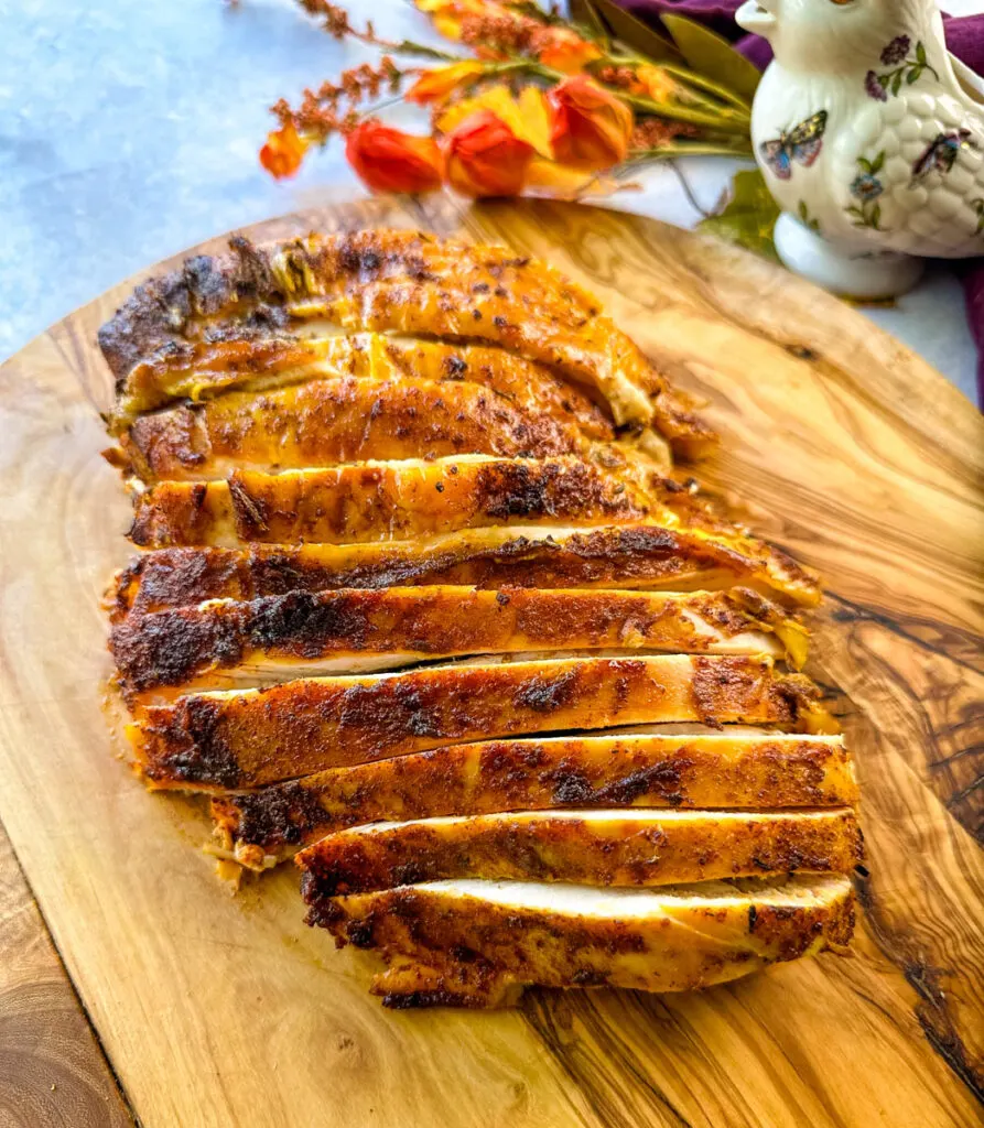 sliced bone in turkey breast on a wooden cutting board