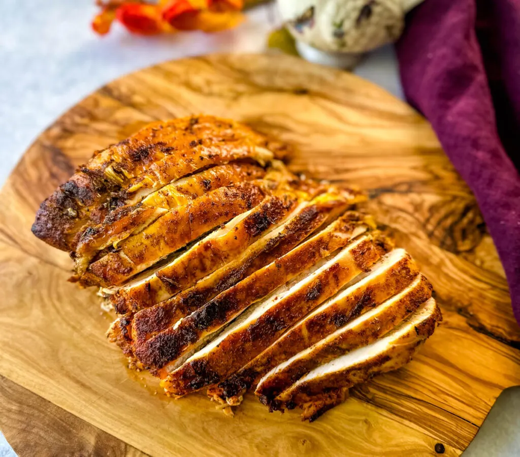 sliced bone in turkey breast on a wooden cutting board