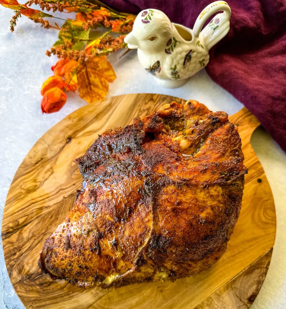 baked roasted bone in turkey breast on a wooden cutting board