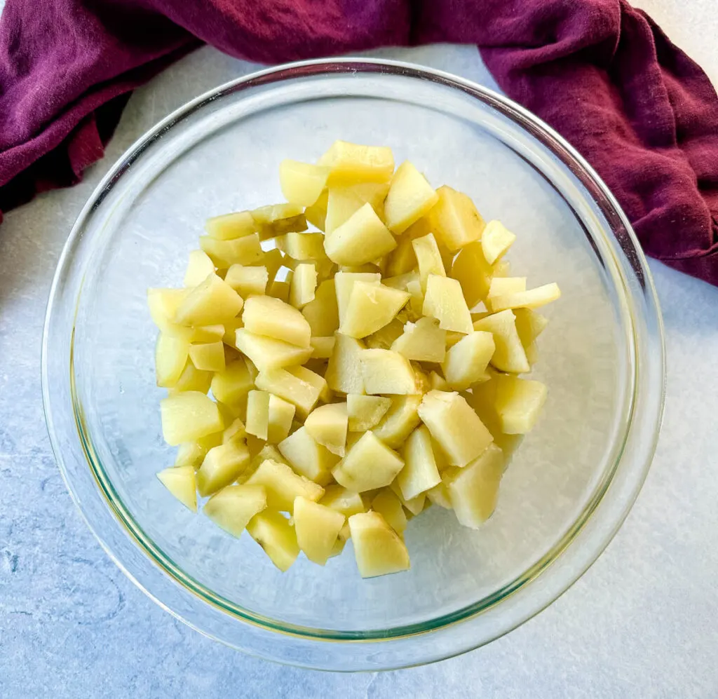 peeled, cooked and diced potatoes in a glass bowl