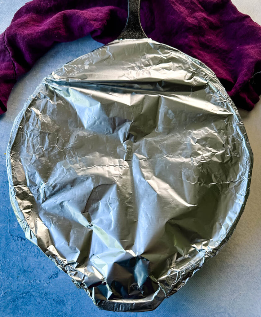 cast iron skillet covered in foil