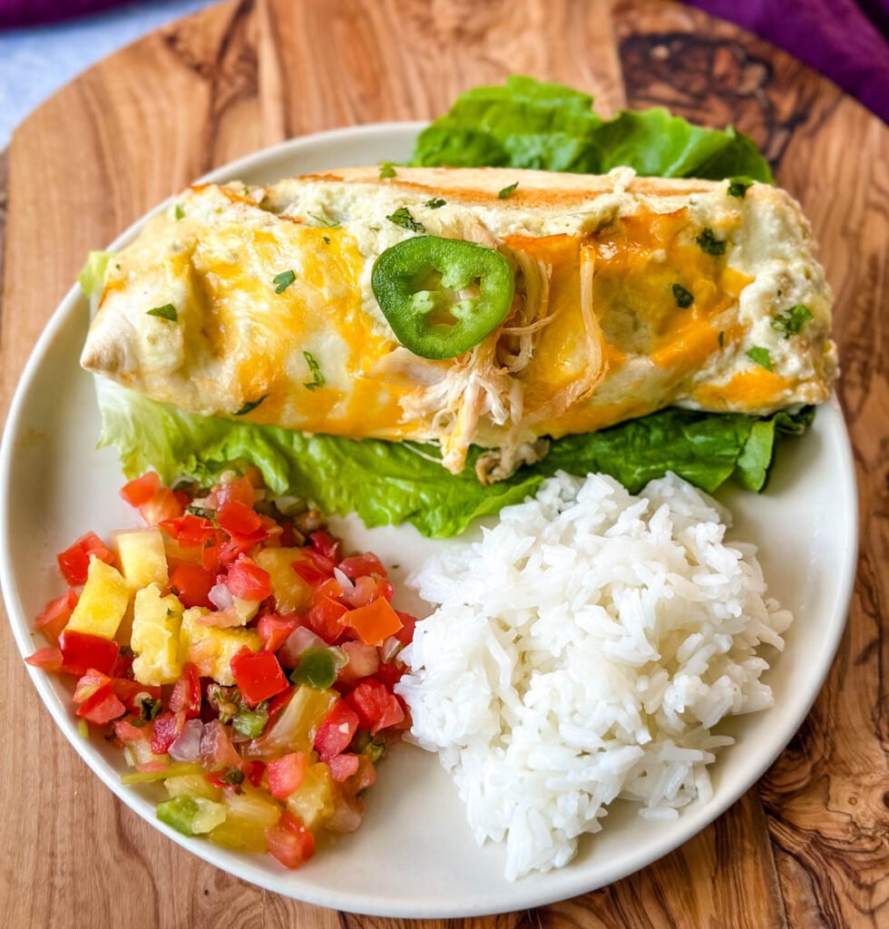 rotisserie chicken enchiladas on a plate with pico de gallo and jalapenos