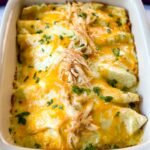 rotisserie chicken enchiladas in a red baking dish