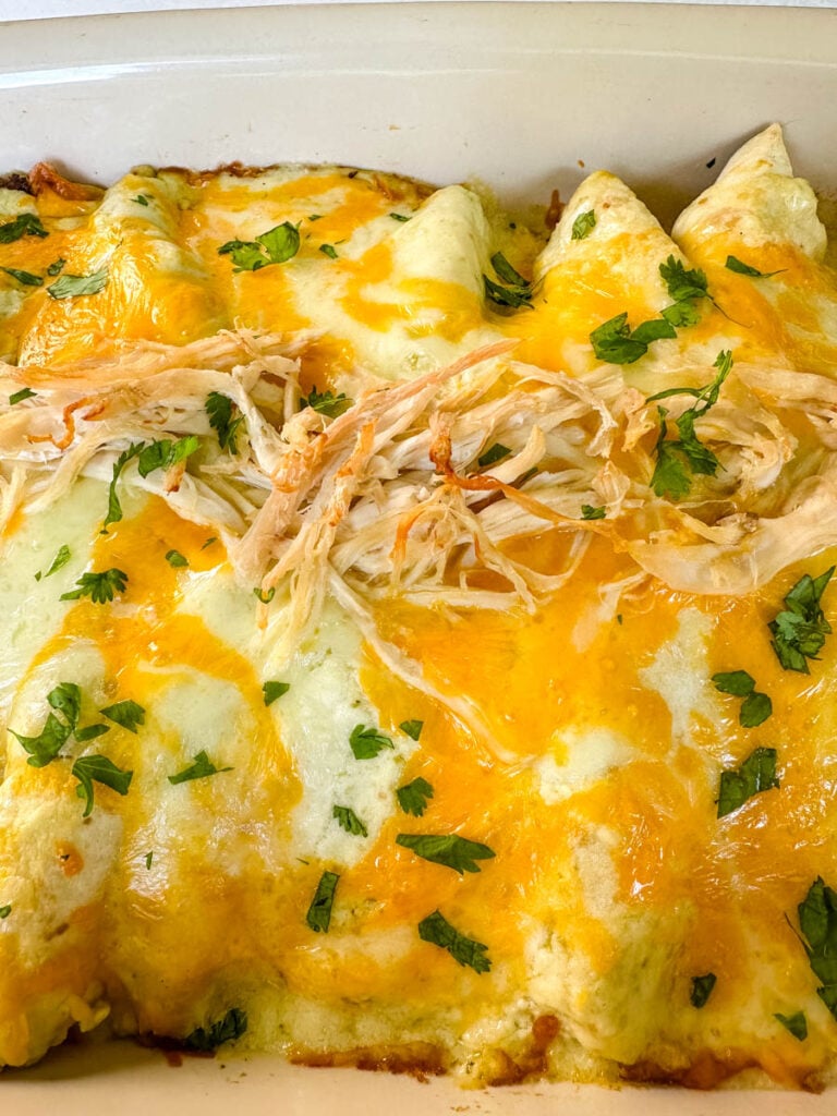 rotisserie chicken enchiladas in a red baking dish