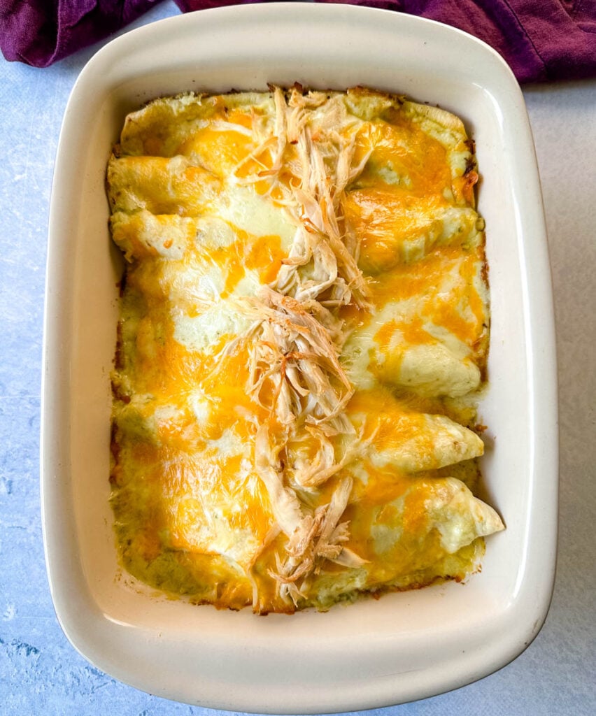 rotisserie chicken enchiladas in a red baking dish