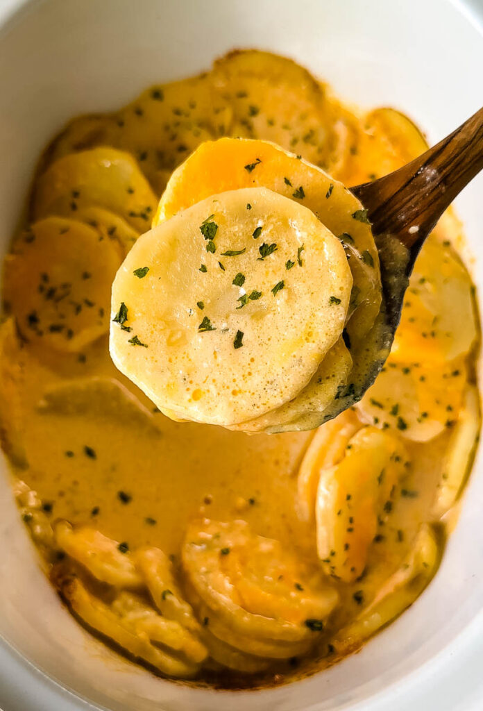 wooden spoonful of slow cooker Crockpot cheesy potatoes