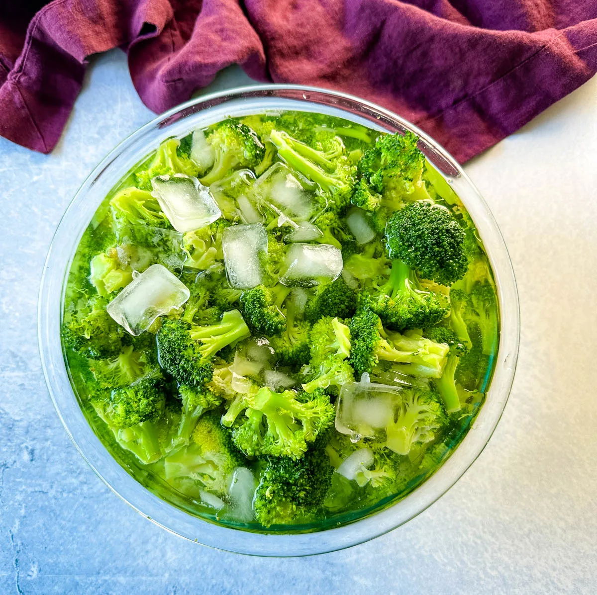 blanched broccoli in a glass bowl with ice