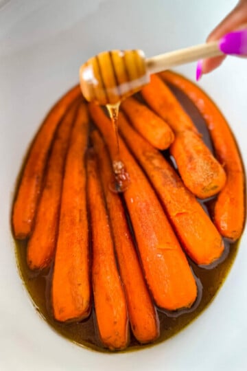 maple syrup drizzled over carrots in a Crockpot slow cooker