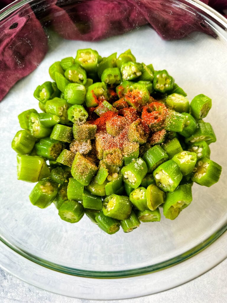 fresh okra in a glass bowl with spices