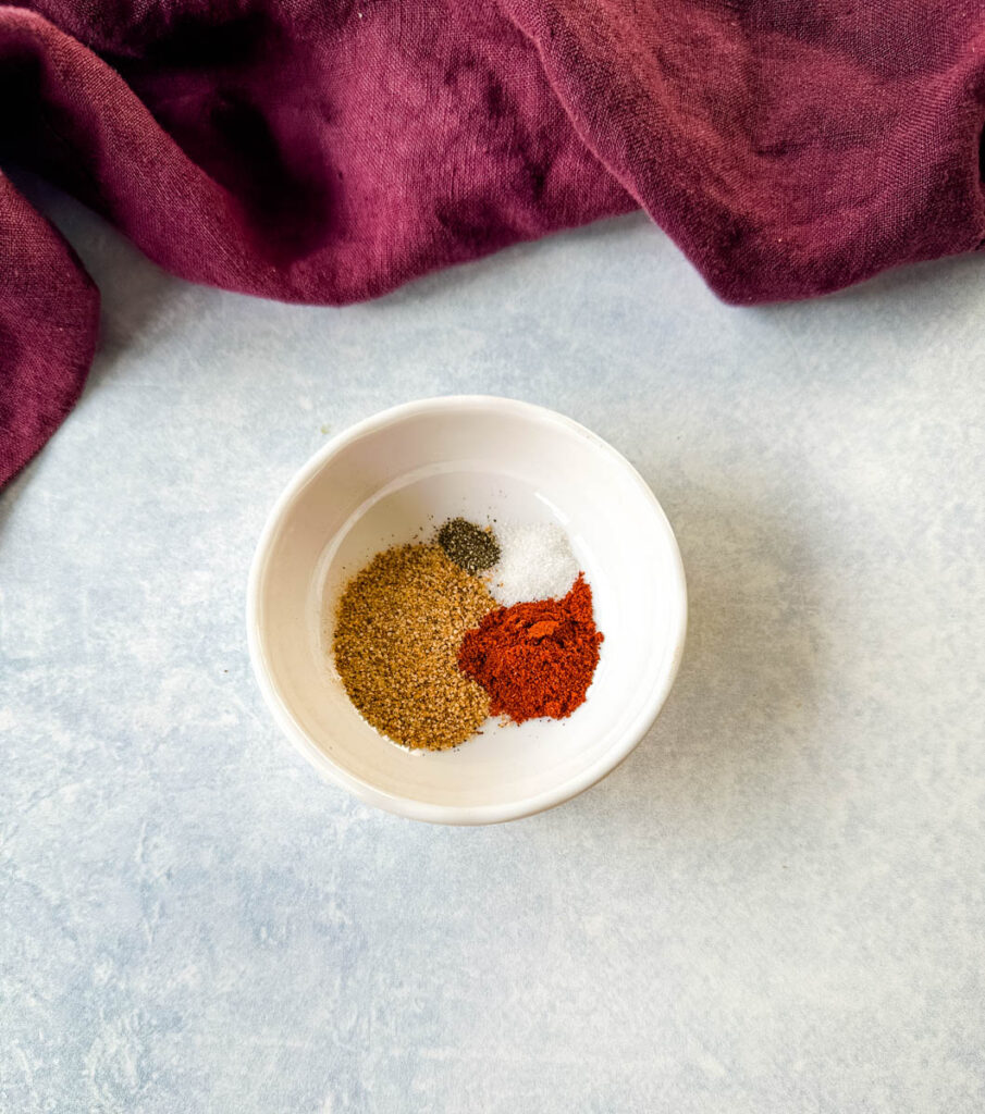 Creole seasoning, smoked paprika, and salt in a white bowl