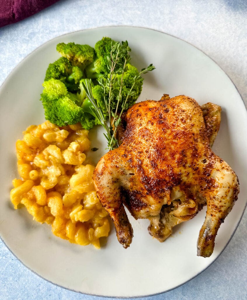 slow cooker Crockpot cornish hen on a plate with mac and cheese and brocooli