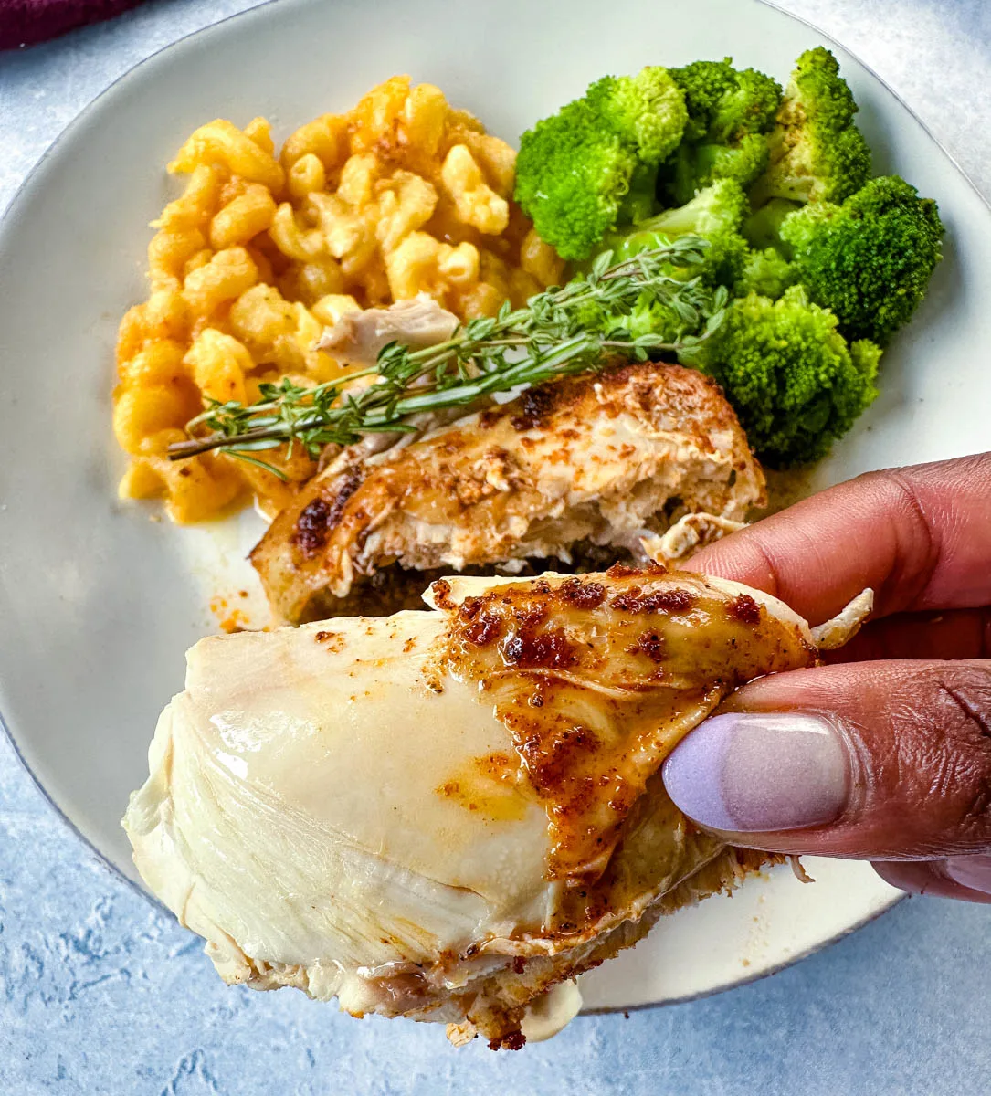 person holding a piece of Crockpot Cornish hens