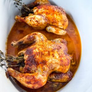 cornish hens in a Crockpot slow cooker with broth and herbs