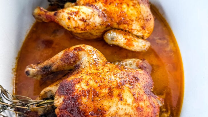 cornish hens in a Crockpot slow cooker with broth and herbs