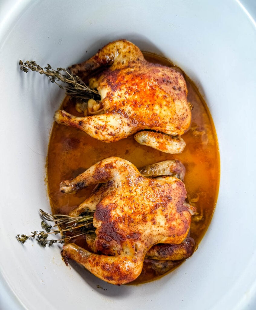 cornish hens in a Crockpot slow cooker with broth and herbs