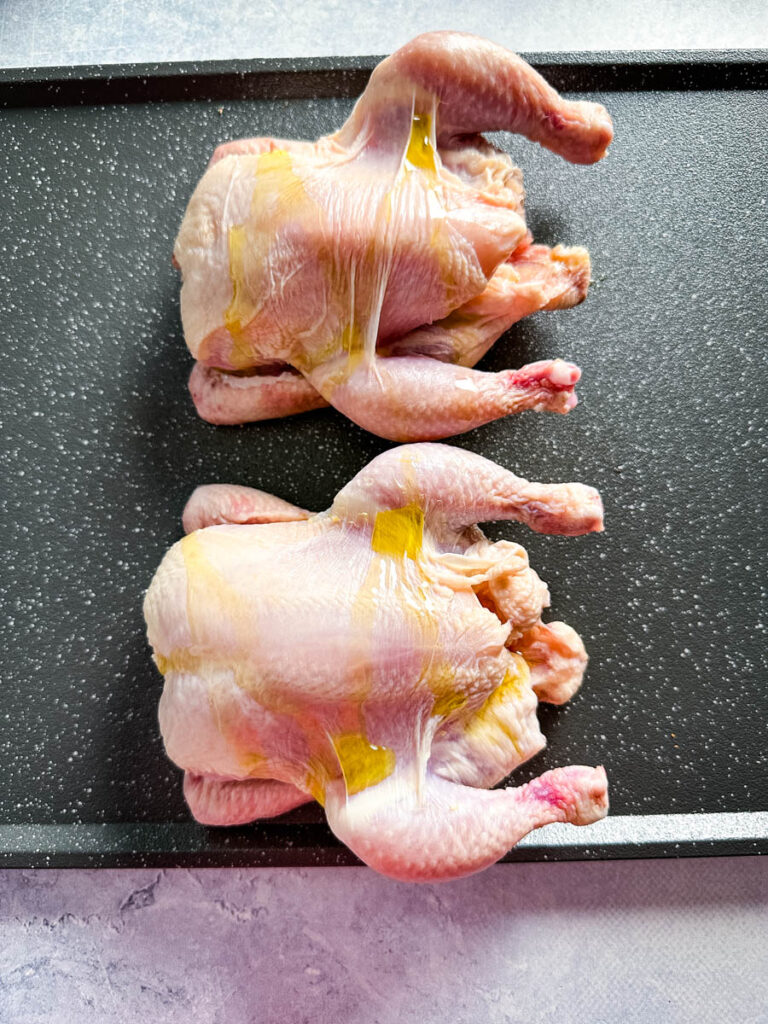 raw Cornish hens drizzled with olive oil