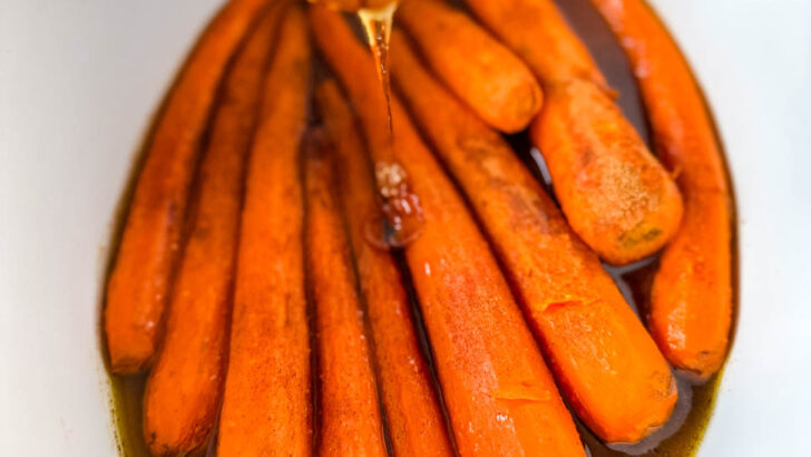 maple syrup drizzled over carrots in a Crockpot slow cooker