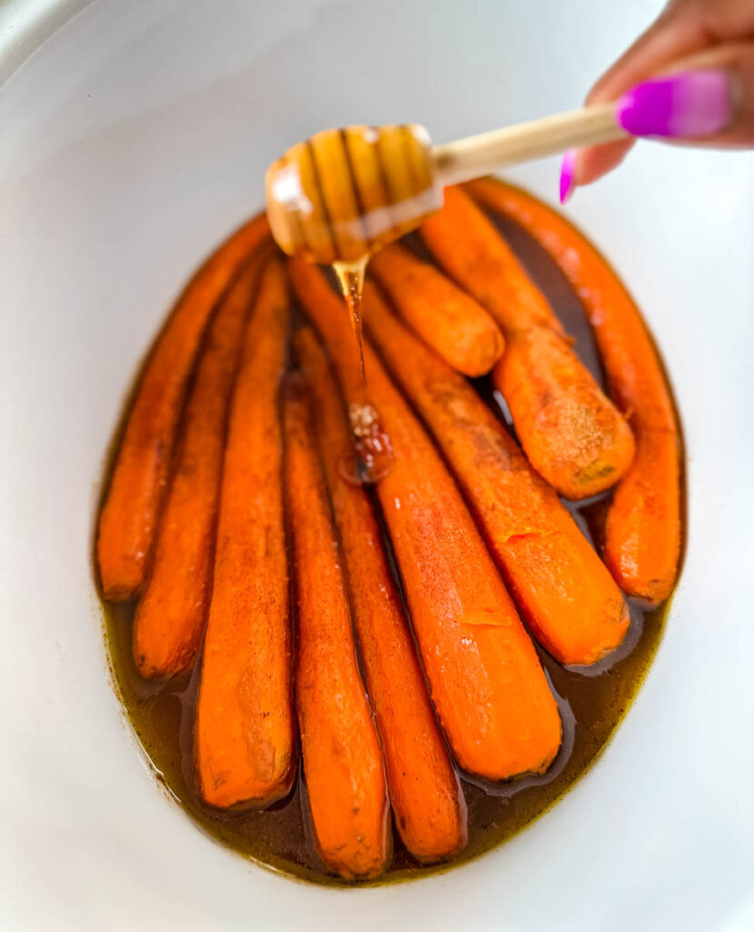 maple syrup drizzled over carrots in a Crockpot slow cooker