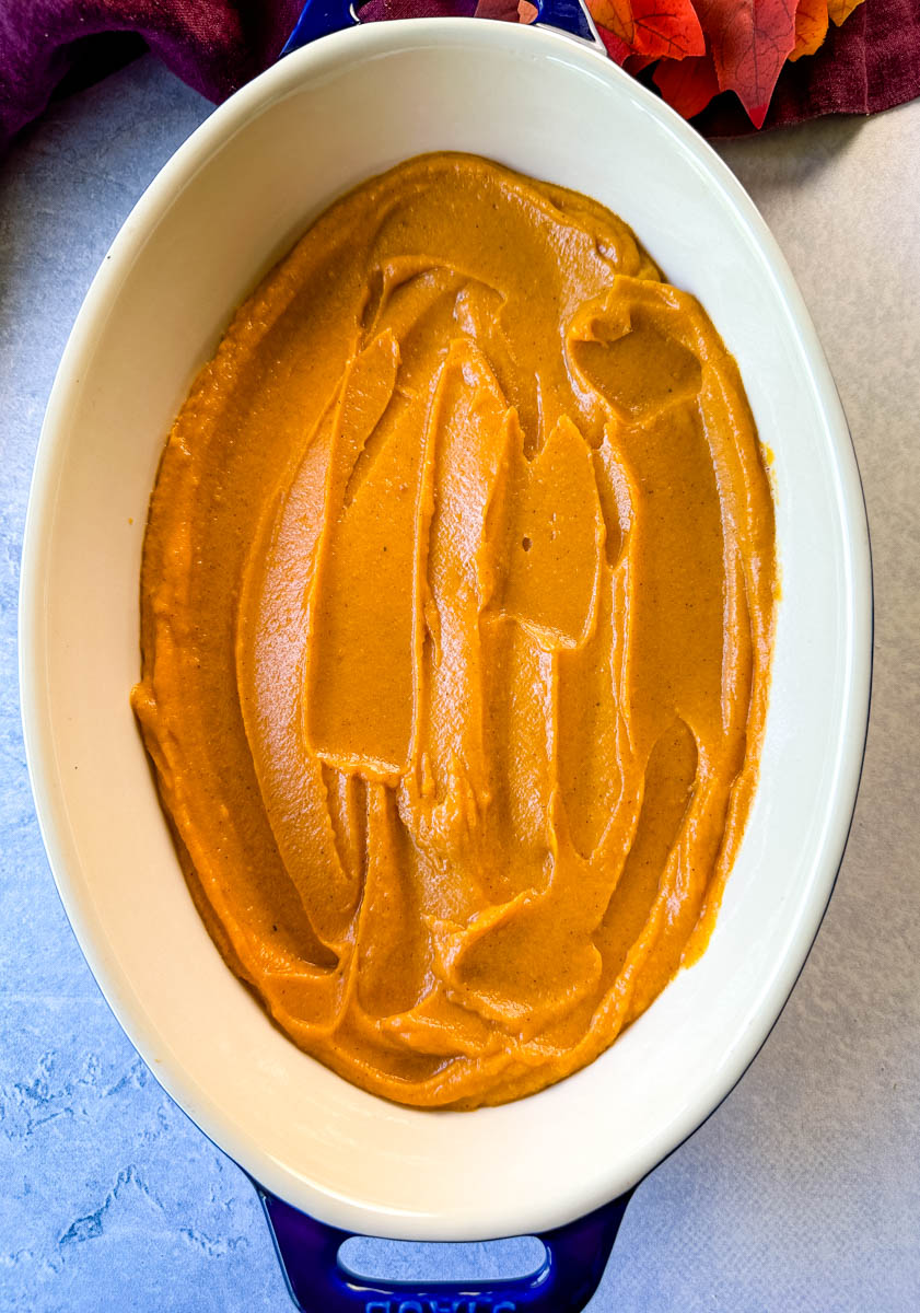 mashed sweet potatoes with cinnamon and sugar in the bottom of a baking dish