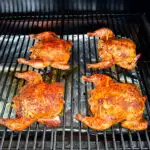 smoked Cornish hens on a sheet pan with fresh herbs