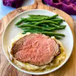 air fryer roast beef with mashed potatoes, gravy, and green beans on a plate