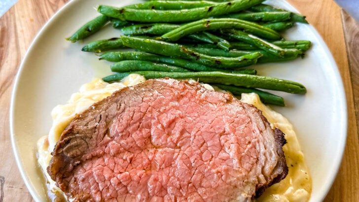 air fryer roast beef with mashed potatoes, gravy, and green beans on a plate