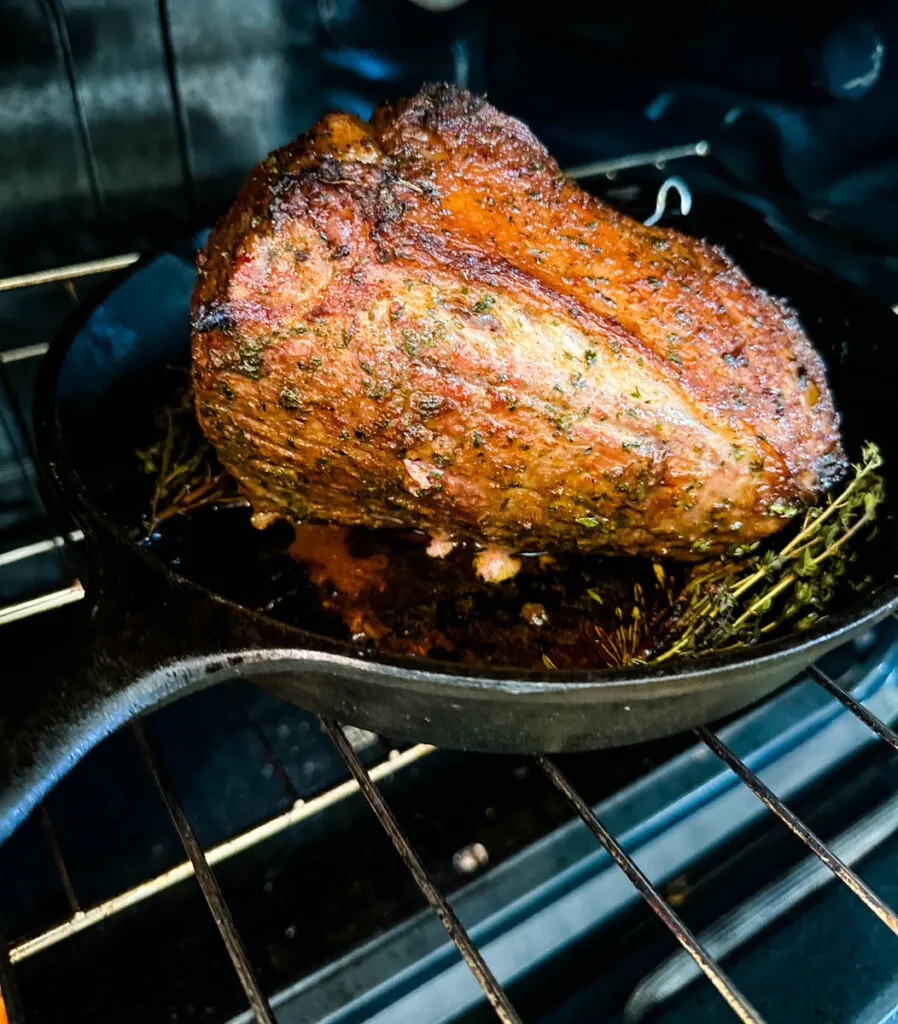 eye of round roast beef in a cast iron skillet in the oven