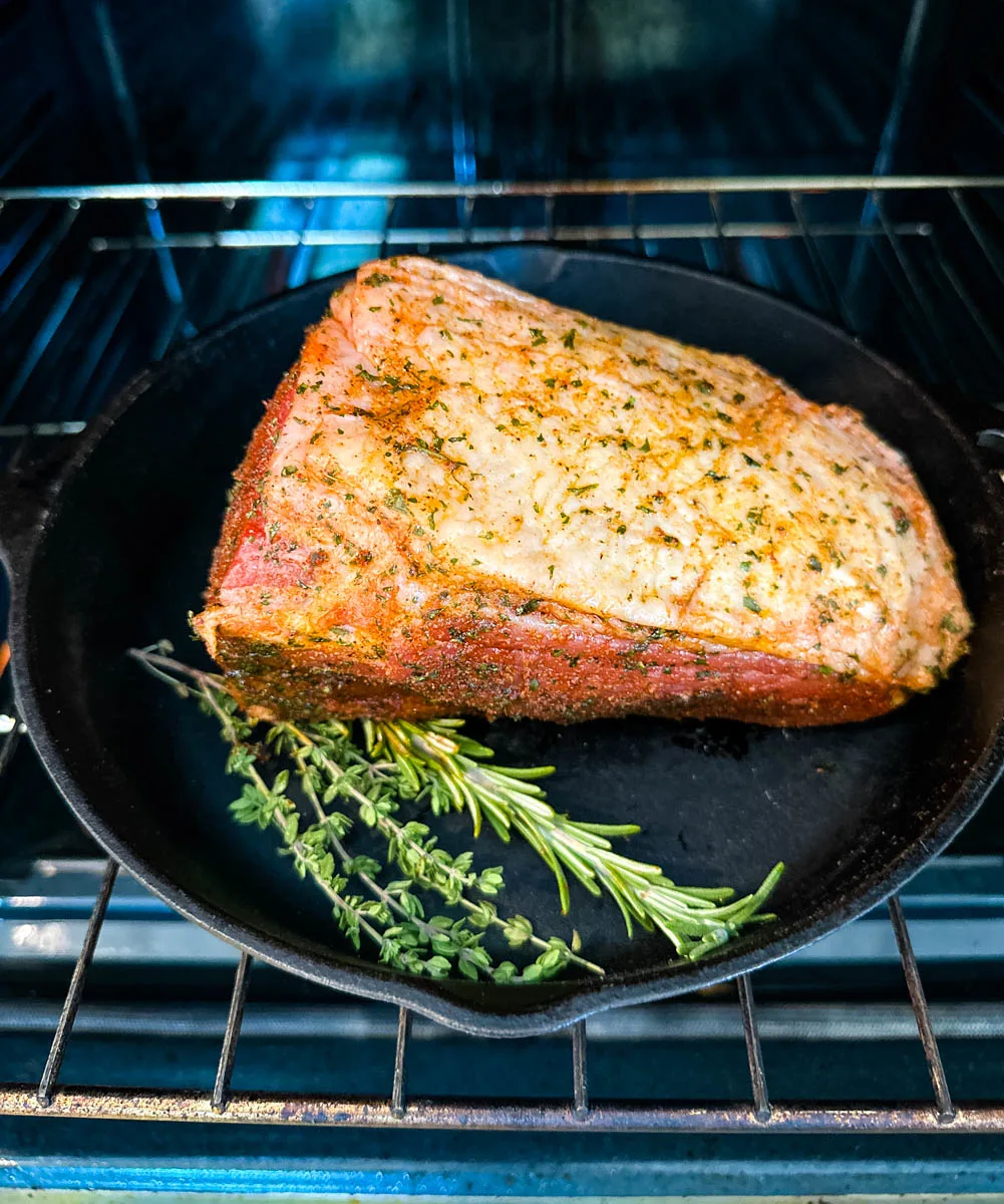 eye of round roast beef in a cast iron skillet in the oven