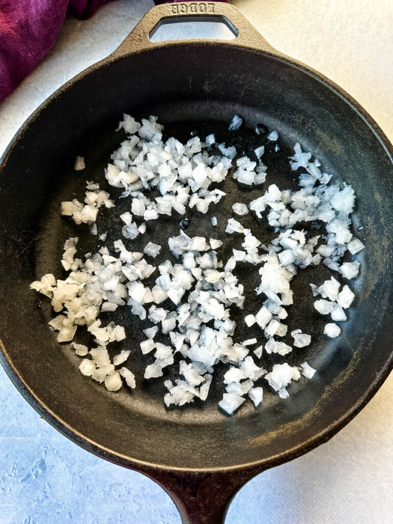 diced white onions in a cast iron skillet