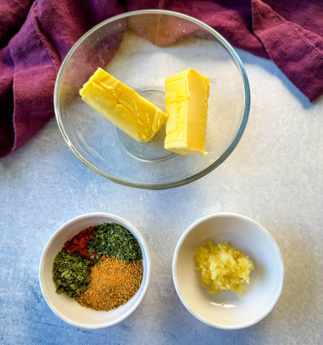 room temperature butter, spices, and minced garlic in separate white bowls